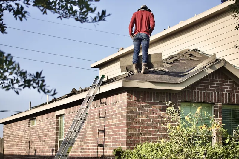 Professional roofer working on a residential roof in Childs